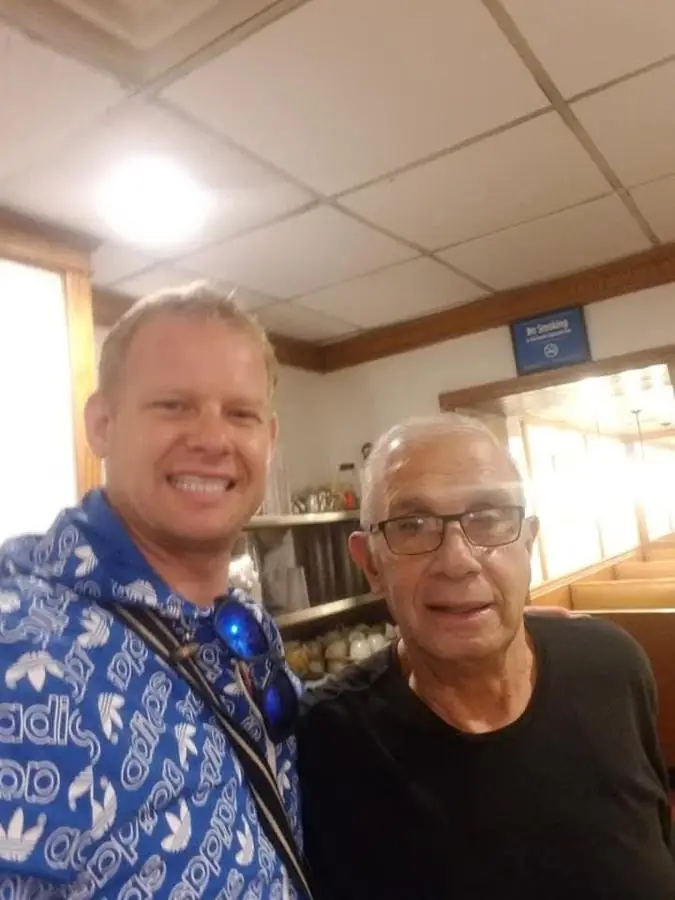 A selfie with an older man in glasses in a diner