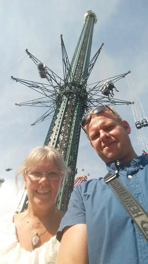 My mom and me taking a selfie under a giant chain swing ride tower in Vienna
